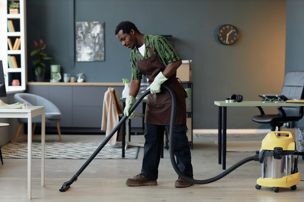 Black Man in Cleaning Service and Vacuuming Floors in Home Or Office